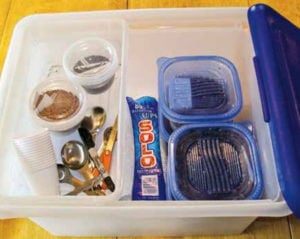 Plastic box containing seeds, scissors, measuring spoons, and cups