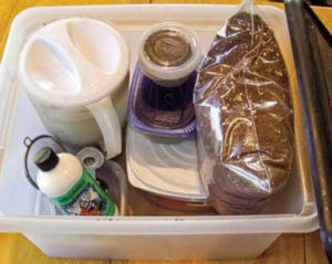 Plastic box containing soil mix, fertilizer, strainer, and measuring spoons